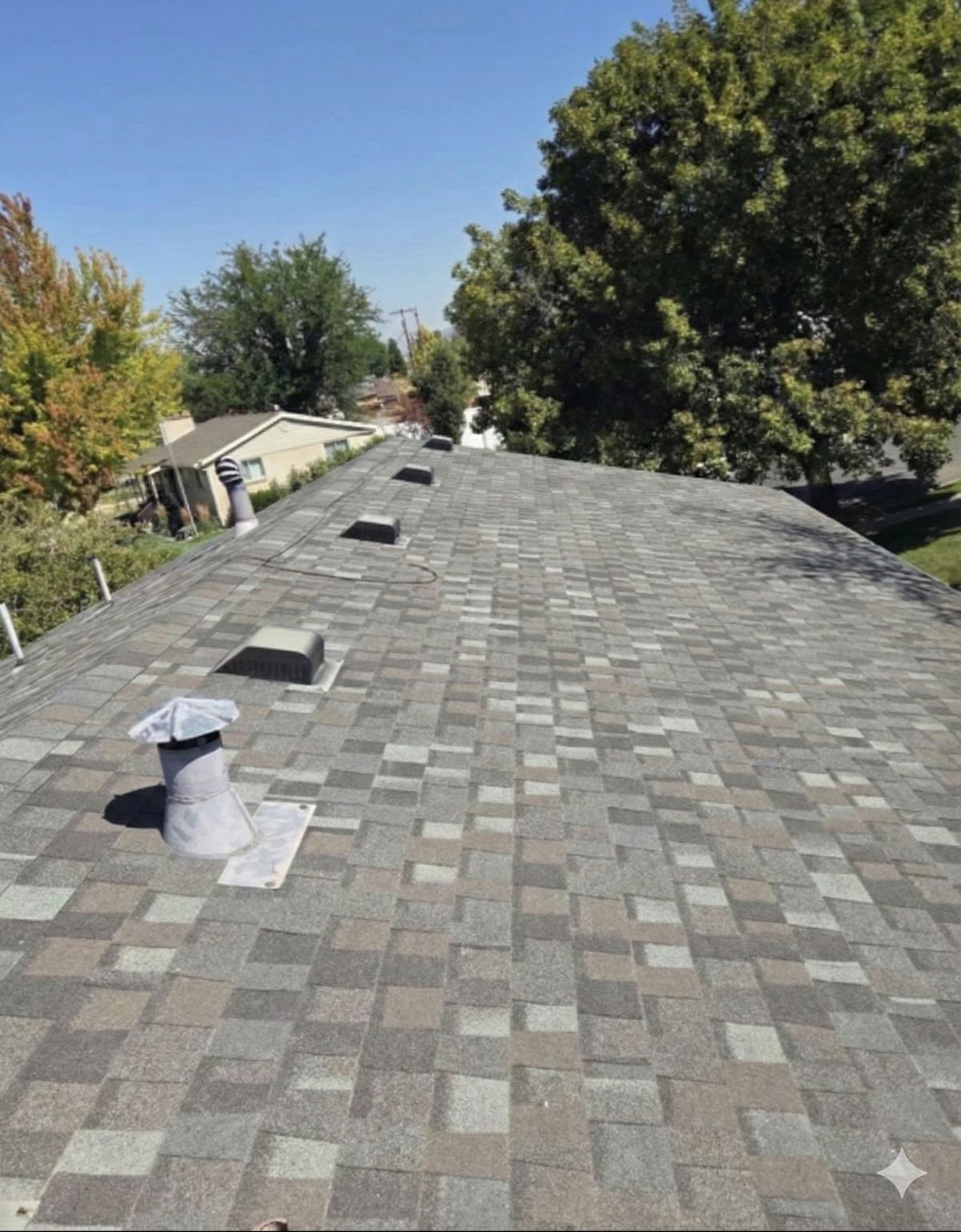 Grey asphalt shingle roof ridge on a Utah home