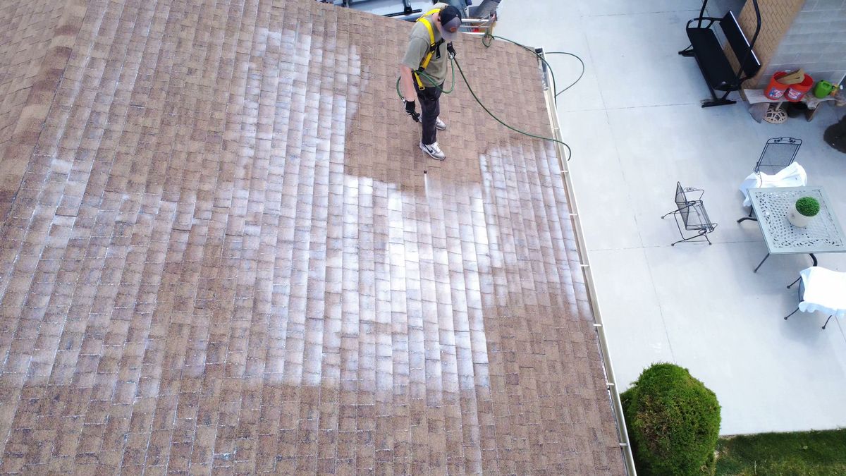 Revive Your Roof technician treating a weathered asphalt shingle roof, on a Wasatch Front home in Utah